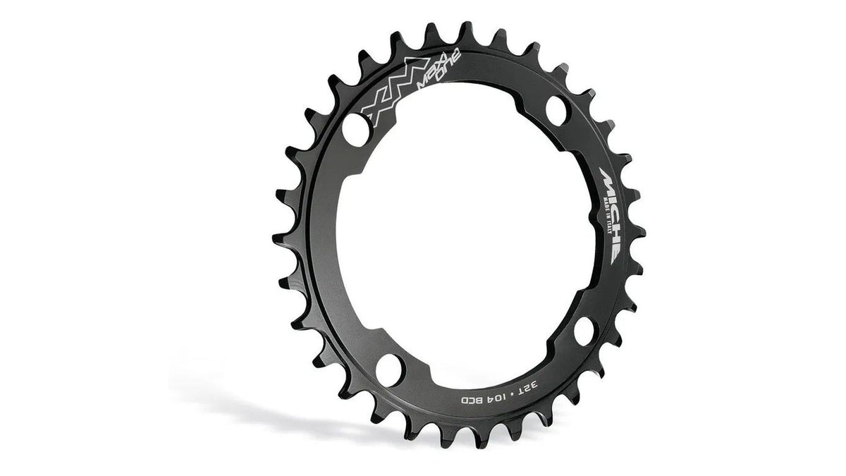 Das MICHE XM Maxi One 36 Zähne ist ein schwarzes E-Bike-Kettenblatt mit gleichmäßig verteilten Wide-Narrow-Zähnen, mehreren Schraubenlöchern zur Befestigung, weißer Logo-Markierung und Beschriftung und ist kompatibel mit Brose-, Yamaha- und Bosch-Motoren.