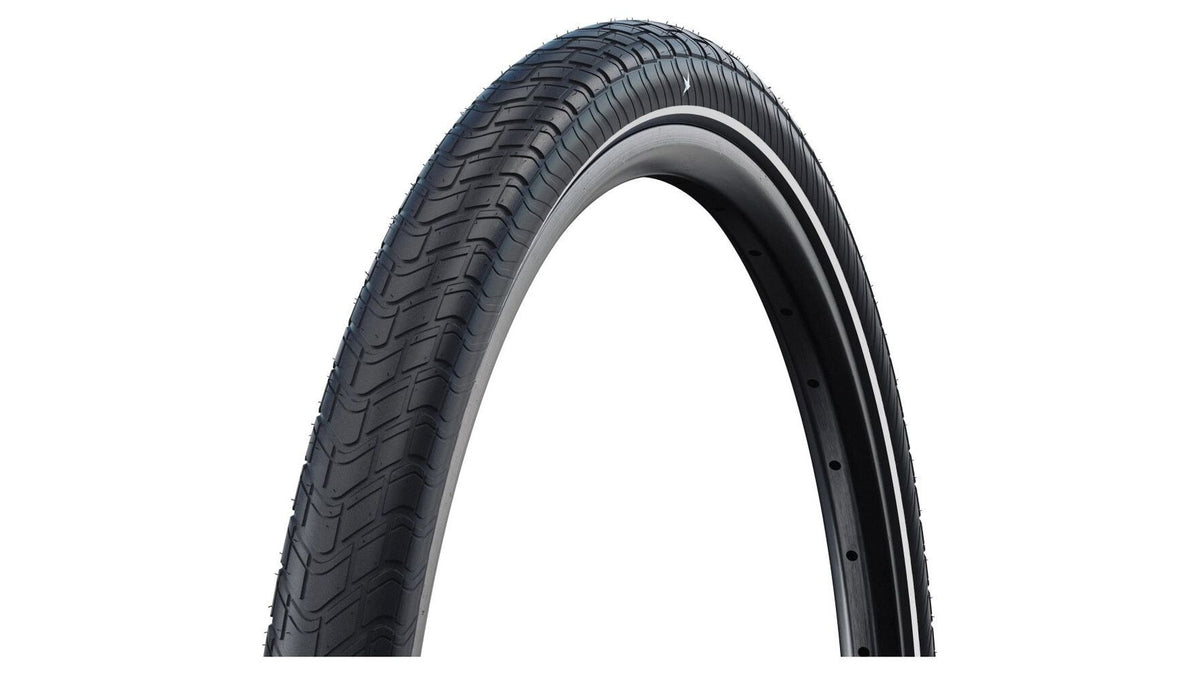 Eine Nahaufnahme des schwarzen SCHWALBE Motion Big Apple 24" Fahrradreifens mit strukturiertem Profil, montiert auf einer Felge, zeigt das geschwungene Profil und die detaillierte Oberfläche vor einem weißen Hintergrund.