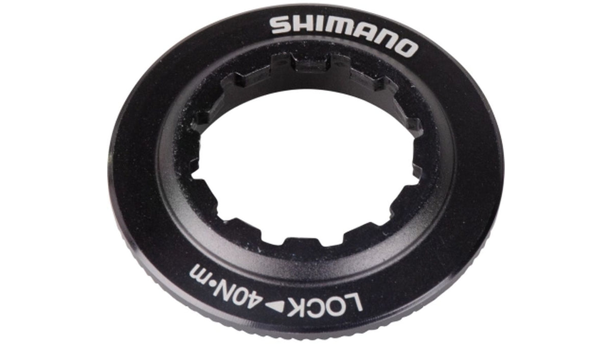 Ein schwarzer Shimano SM-RT81/SM-RT67 Verschluss mit Innenverzahnung und weißem "SHIMANO"- und "LOCK 40N-m"-Schriftzug auf der Oberseite, entwickelt für die effiziente Sicherung von Bremsscheiben.