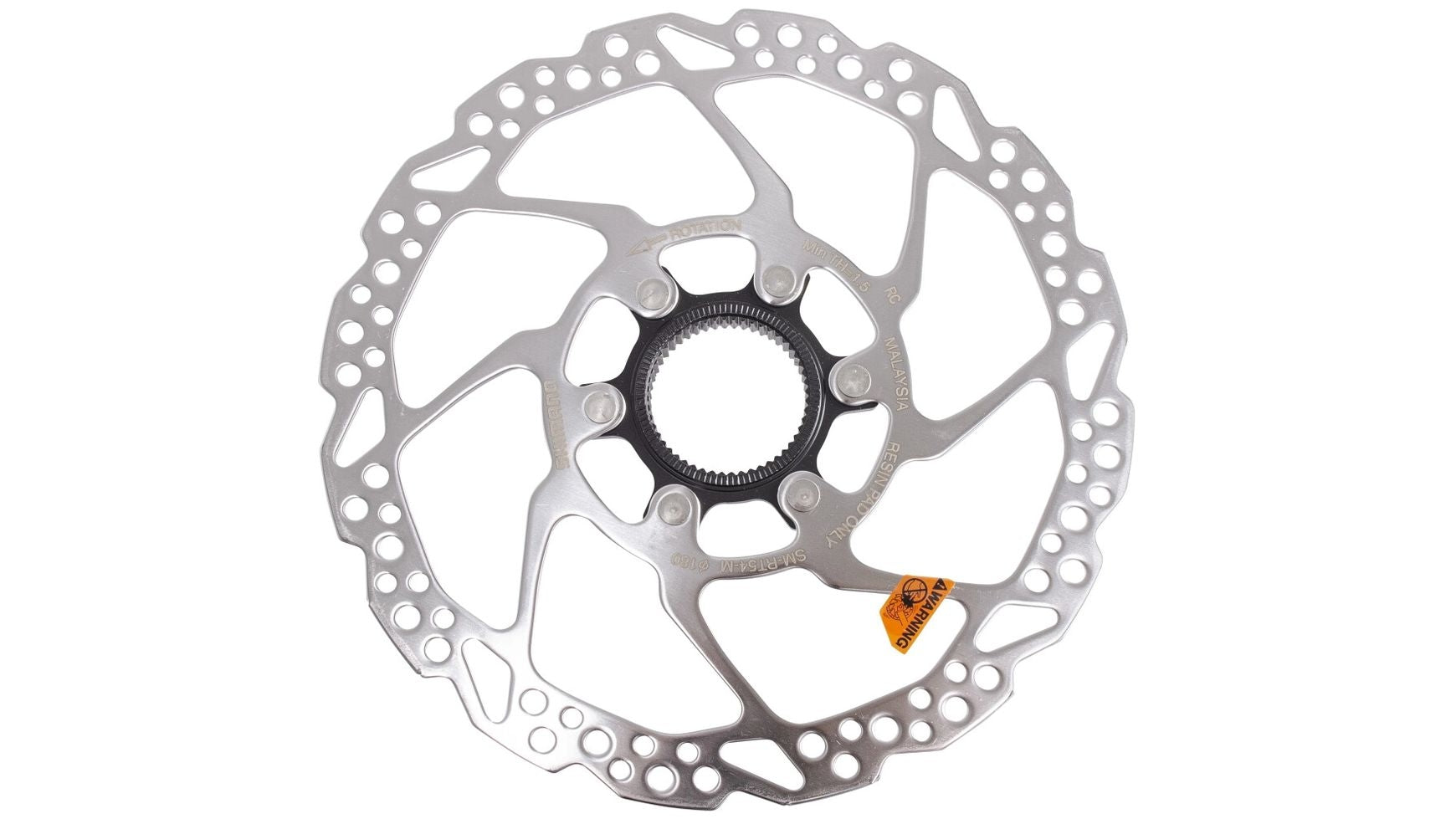 Diese silberfarbene SHIMANO DEORE SM-RT54-Bremsscheibe zeichnet sich durch ein markantes, gemustertes Ausschnittdesign und ein kleines orangefarbenes Warnschild in der Nähe der Mitte aus und verfügt über ein zuverlässiges Center-Lock-Befestigungssystem.