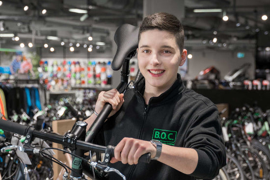 Ein Fachberater von B.O.C. hält ein Fahrrad in einer Fahrrad-Filiale von B.O.C.