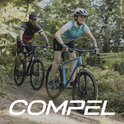 Zwei Fahrradfahrer auf Mountainbikes von der Marke Compel in einem Wald.