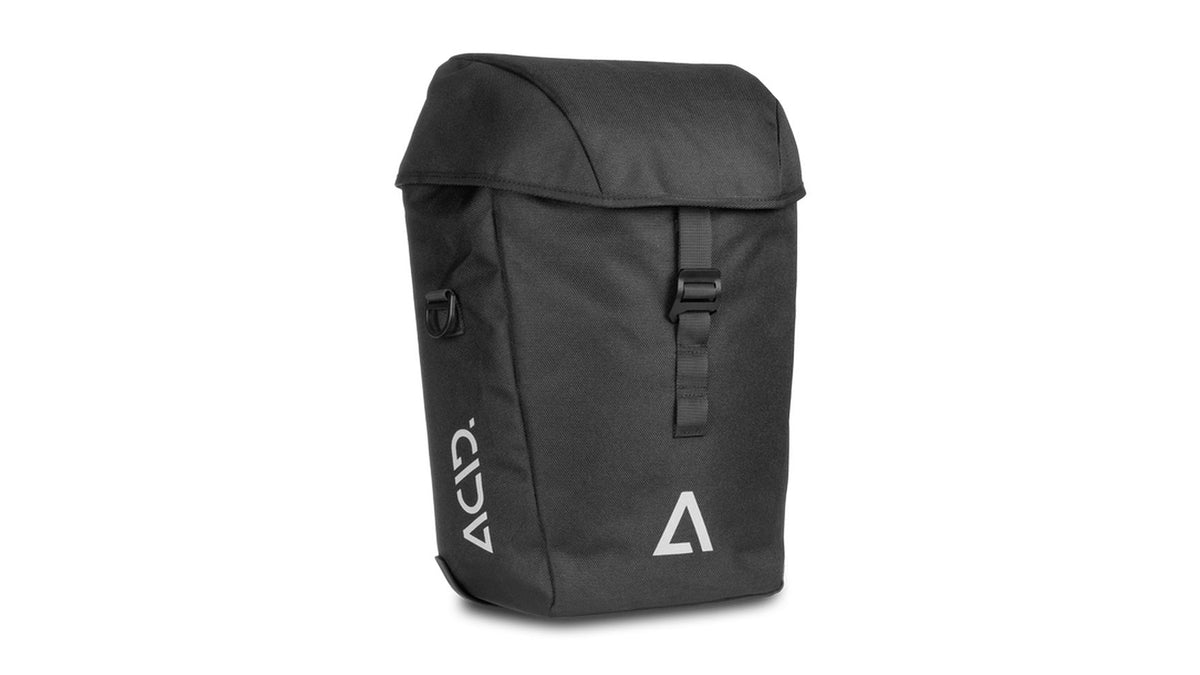 Der ACID CITY 15 SMLink 2.0 ist eine schwarze, rechteckige Fahrradtasche mit Klappe und Schnallenverschluss, weißen, geometrischen Logos und ACID-Schriftzug auf der Vorderseite. Sie lässt sich mit dem SMLink 2.0-System einfach an Ihrem Fahrrad befestigen.
