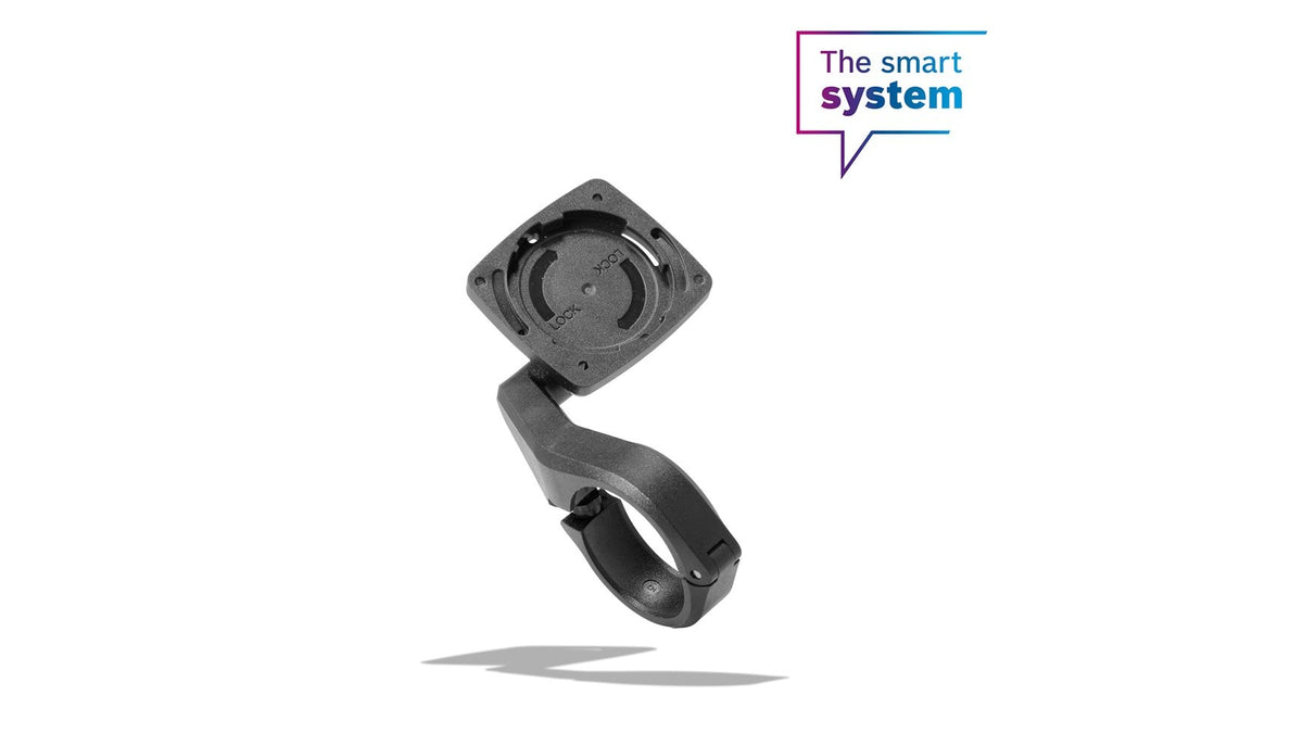 Eine schwarze Kunststoff-Fahrradhalterung „BOSCH Intuvia 100 31,8 mm Halter“ mit rundem Sockel schwebt vor einem weißen Hintergrund. In der oberen rechten Ecke ist in einer Sprechblase der Text „Das intelligente System“ zu lesen.