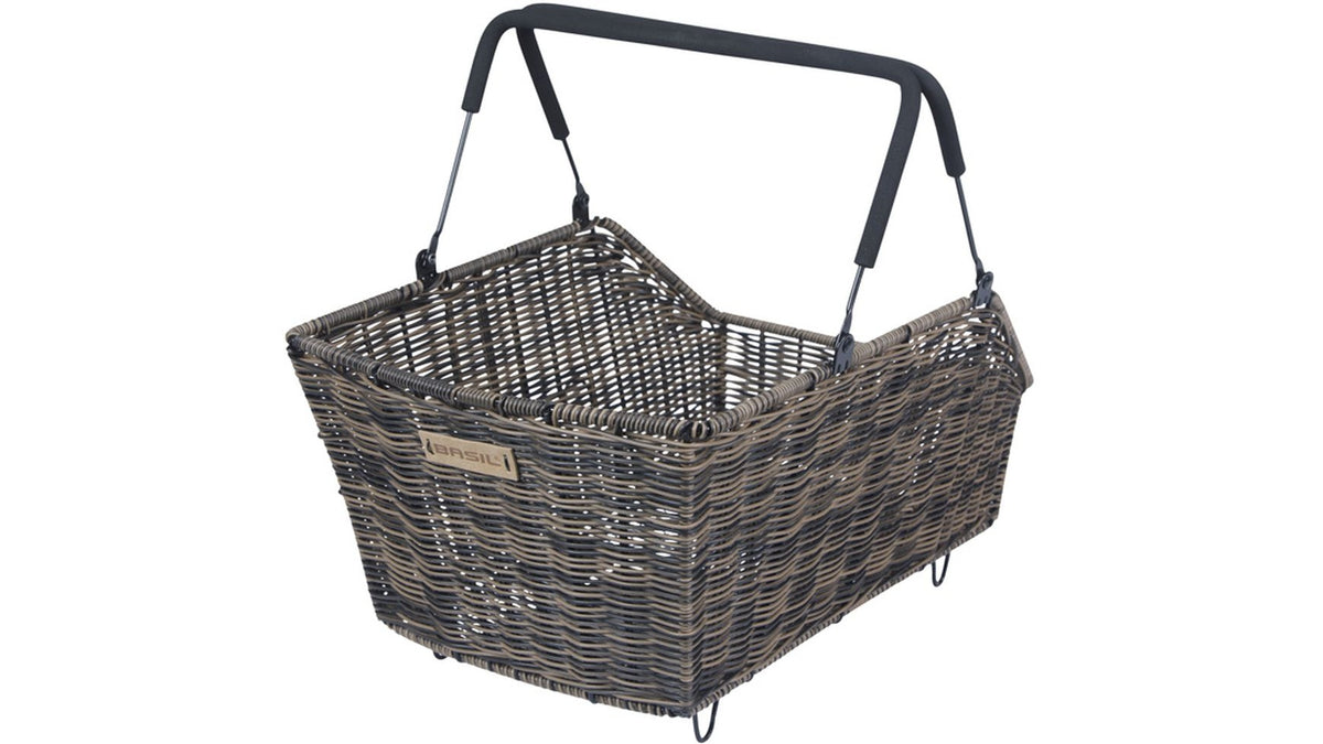 Der BASIL Cento Rattan Look HR Korb ist ein rechteckiger, geflochtener Fahrradkorb mit schwarz gepolsterten Metallgriffen, einem rustikalen Rattan-Stil und einem kleinen Etikett - perfekt als Gepäckträgerkorb.
