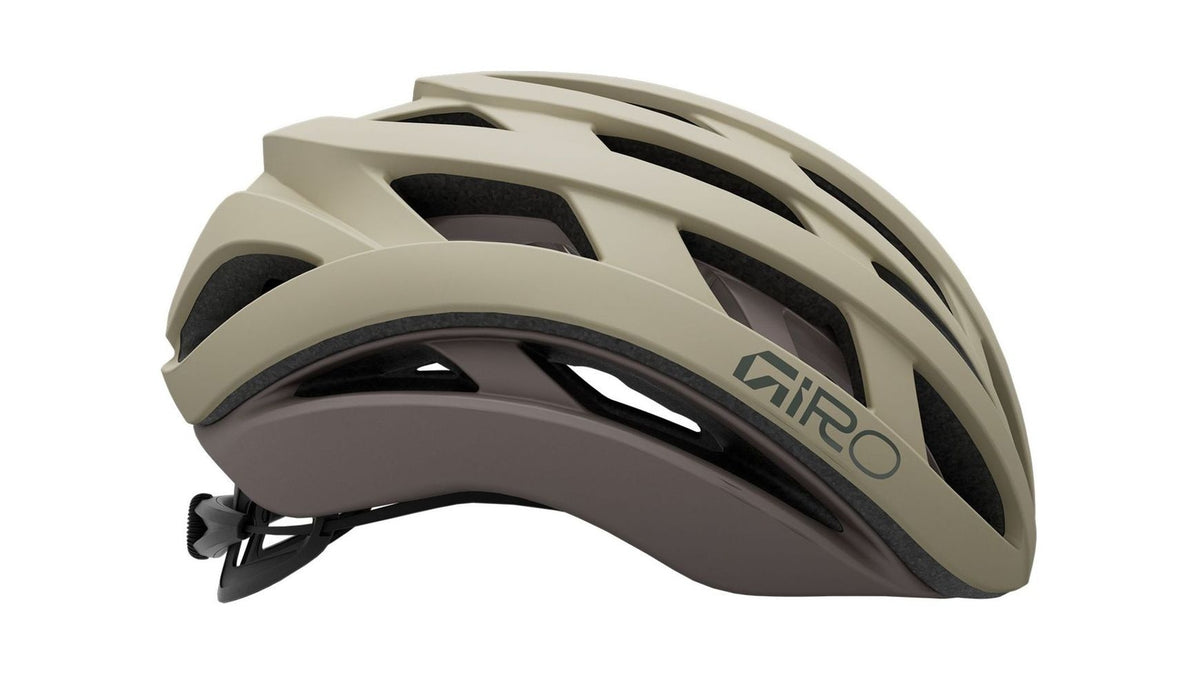 Eine Seitenansicht des Fahrradhelms „GIRO Helios Spherical“ in Beige und Grau, mit aerodynamischen Belüftungsöffnungen und dem GIRO-Logo im vorderen Bereich. Ausgestattet mit fortschrittlichem MIPS-Kopf- und Hirnschutz sowie der Spherical-Technologie für herausragende Sicherheit und Leistung.