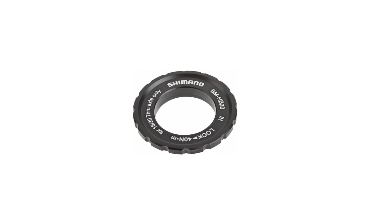 Ein schwarzer SHIMANO SM-HB20 Center-Lock-Ring mit silberner Beschriftung und Teilenummer ist isoliert auf weißem Hintergrund abgebildet. Er wird zur Befestigung von Center-Lock-Bremsscheiben-Komponenten am Fahrrad verwendet.