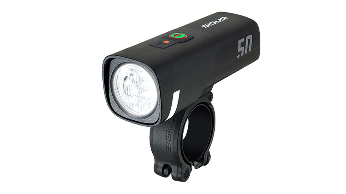 Die schwarze SIGMA Sigma AURA 50 USB Frontleuchte verfügt über eine runde LED-Linse, einen Einschaltknopf an der Oberseite und eine angebrachte Lenkerhalterung.