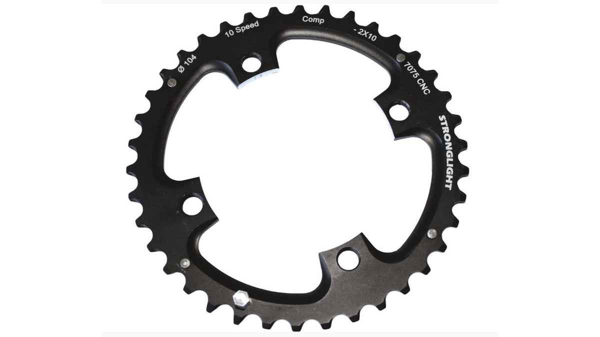Das schwarze Stronglight MTB 104/64 Kettenblatt mit der Aufschrift "STRONGLIGHT" verfügt über 42 Zähne, Schraubenlöcher und weiße Angaben wie "10 Speed", "Comp", "2x10-fach Schaltsysteme", "4-104" und ist aus 7075 T6 Aluminium gefertigt.