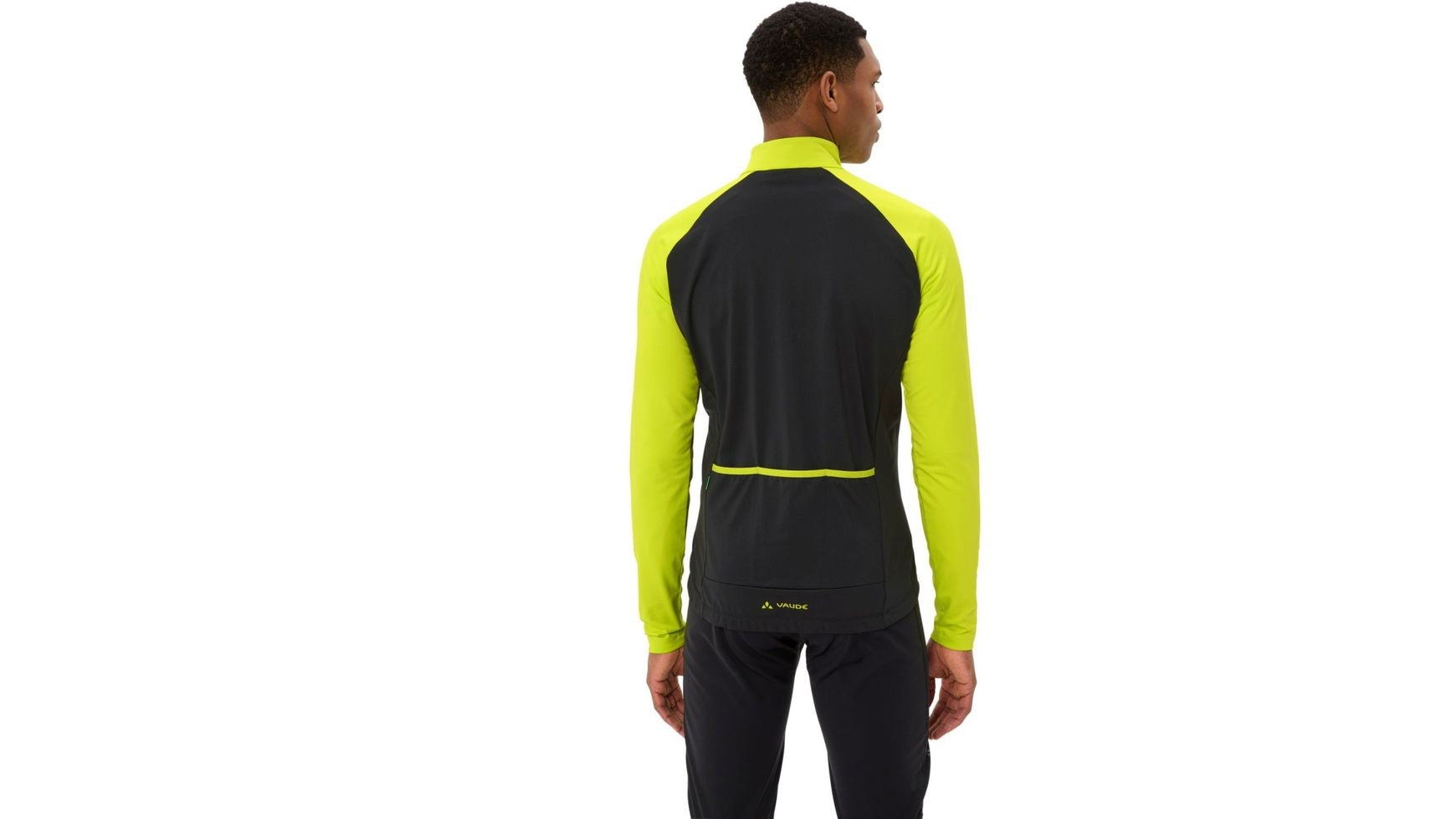 Ein Mann steht mit dem Rücken zur Kamera, trägt eine schwarz-neongelbe VAUDE Men's Posta LS Tricot II Jacke und eine schwarze Hose vor einem schlichten weißen Hintergrund - ideal für Gravelbike- oder Rennrad-Fans.